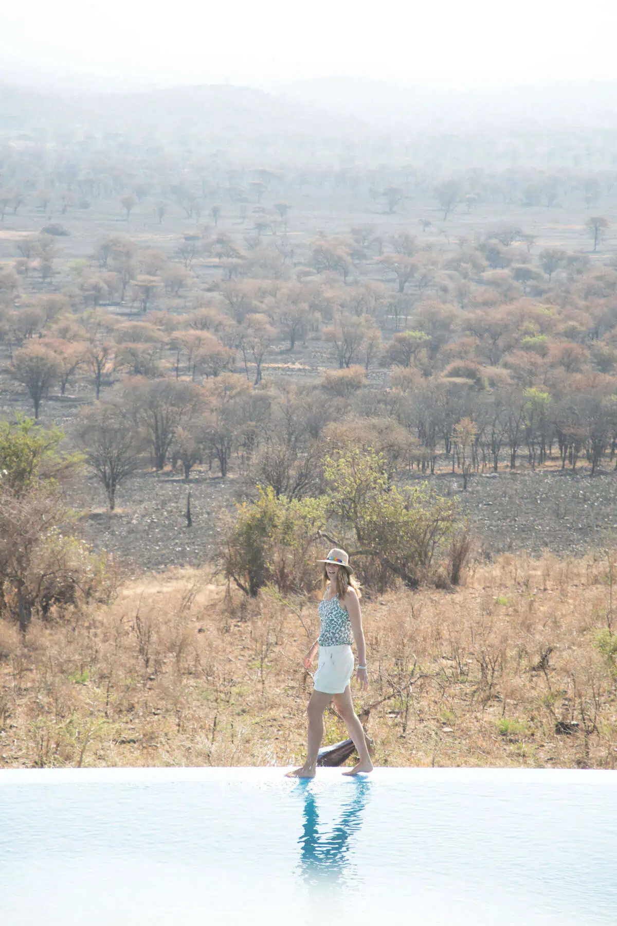 Me walking along the edge of an infinity pool looking out over bushland