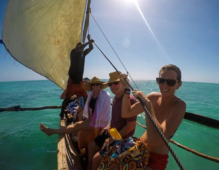 Me and friends sailing on a traditional dhow with a large sail over turquoise water