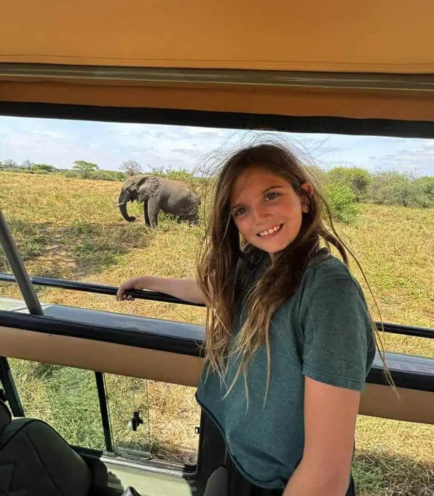 African safari girl with elephant in the wild, exploring wildlife safaris in Africa, children wildlife adventure, safari tours for families, travel with kids in Africa.