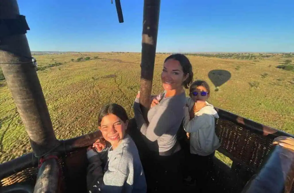 Hot air balloon safari over the African savannah with a smiling family enjoying an unforgettable wildlife adventure. Perfect for safari tours and wildlife exploration in Africa.