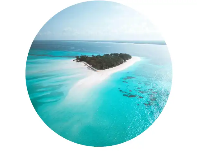 Aerial view of a pristine tropical island surrounded by turquoise waters and coral reefs, perfect for an unforgettable African safari and beach holiday experience.