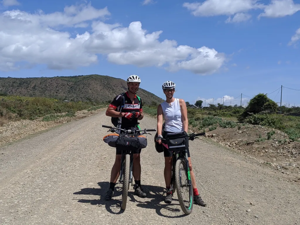Me and a friend with our bikes on a dirt road, cycling around Mount Meru
